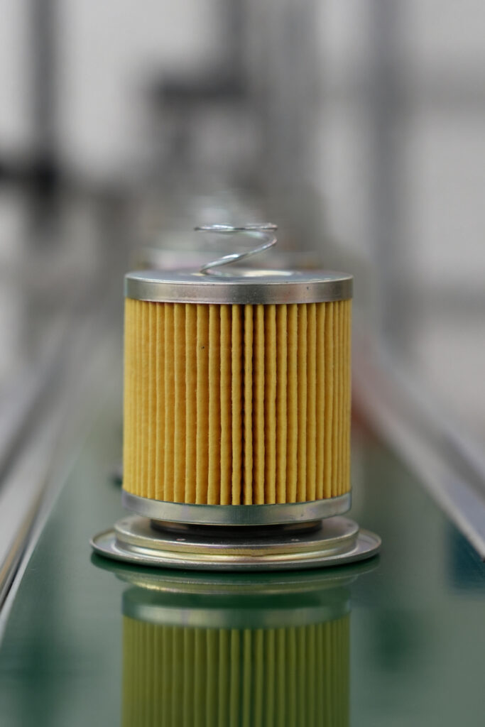 Filter element on a conveyor beneath an industrial machine
